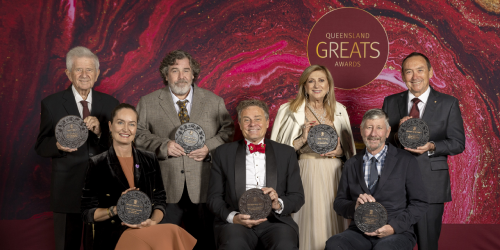 Queensland Great Awards Winners sitting and standing with their awards