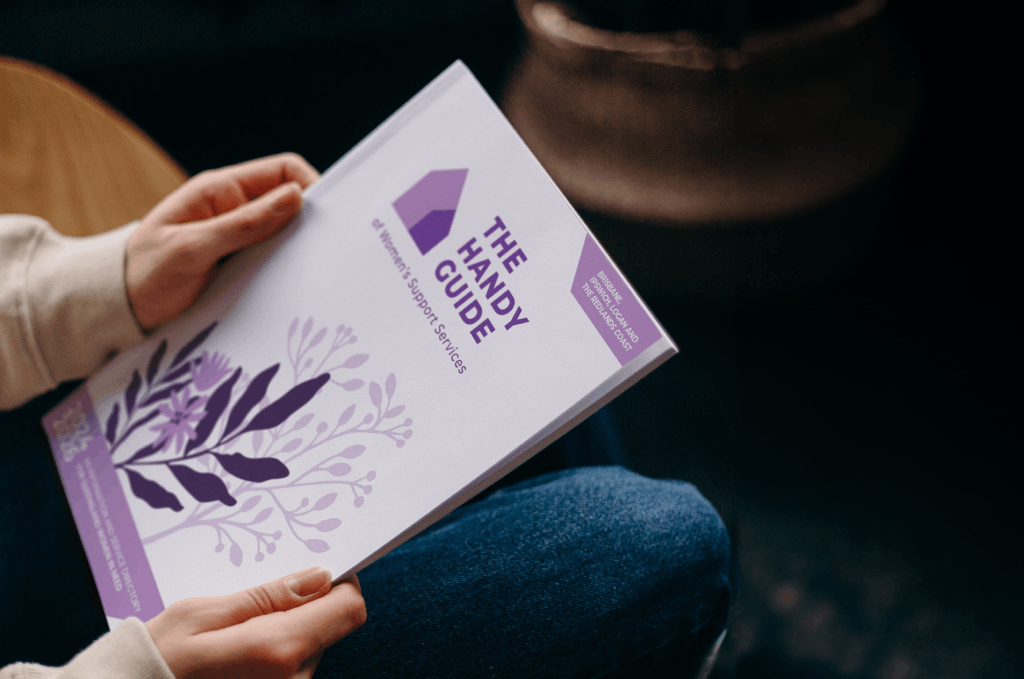 A woman holding a printed copy of The Handy Guide