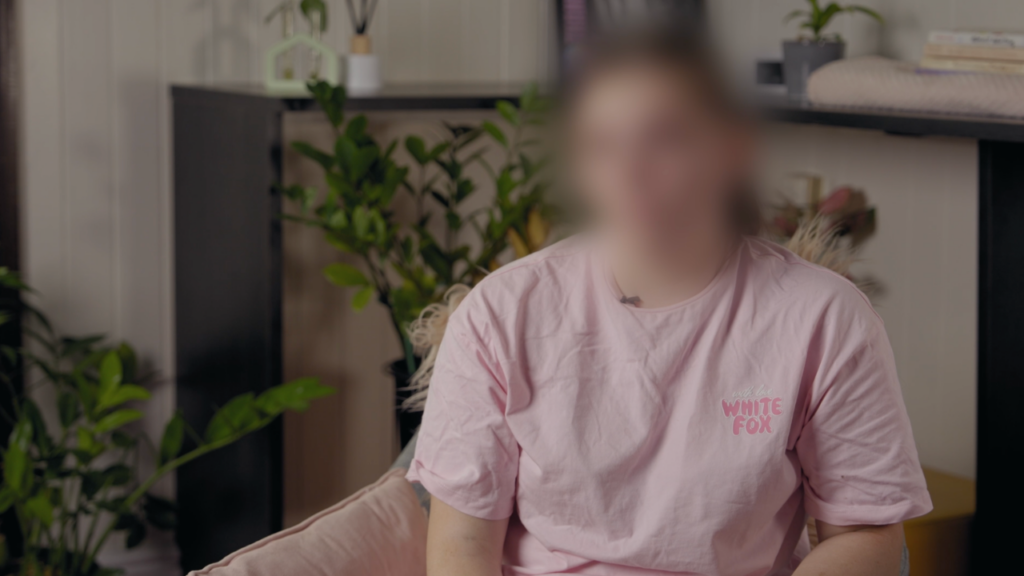 Woman sitting in a chair with her face blurred